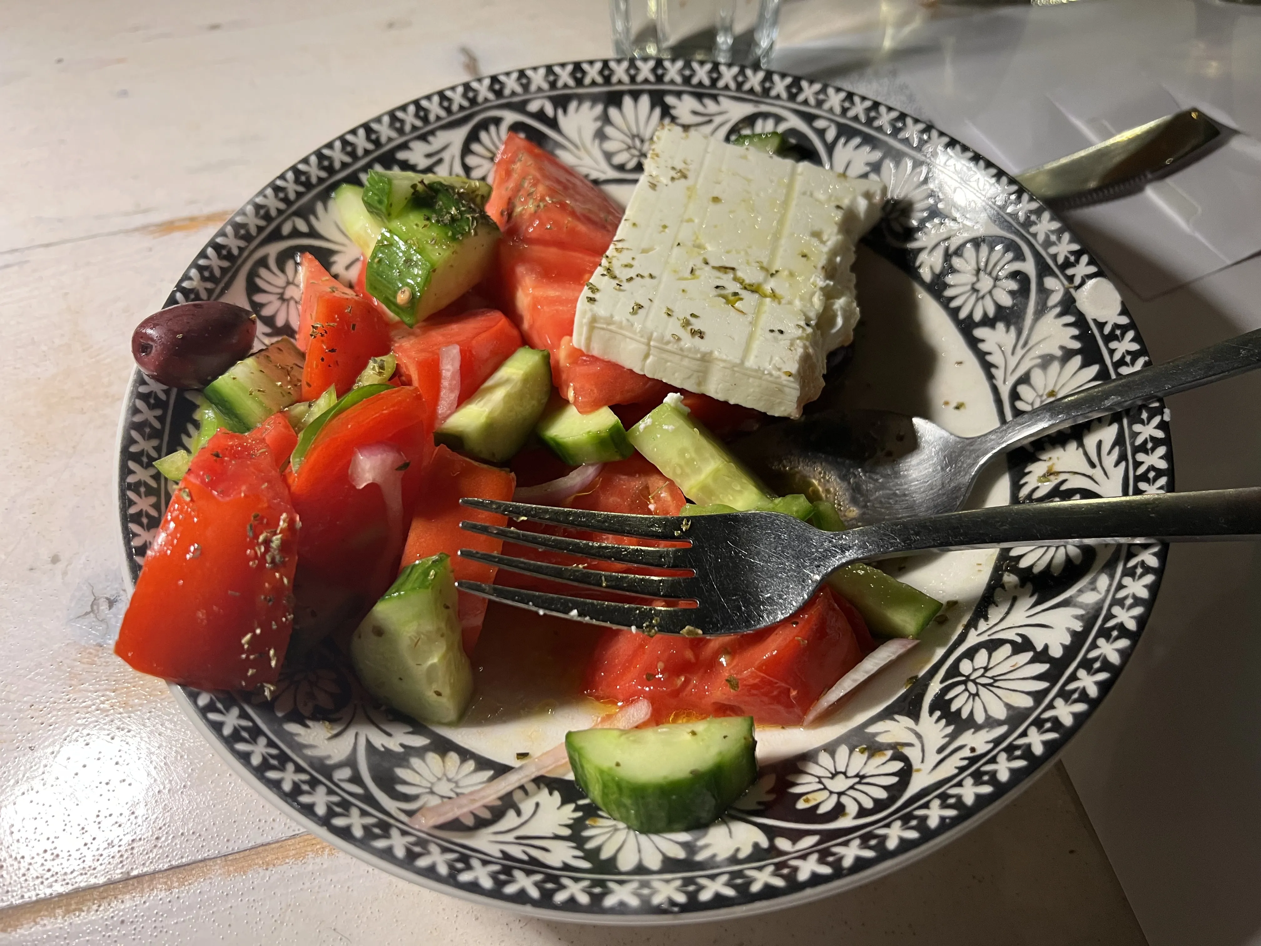 Tabletop spread with salads, dips, olives and fresh greens