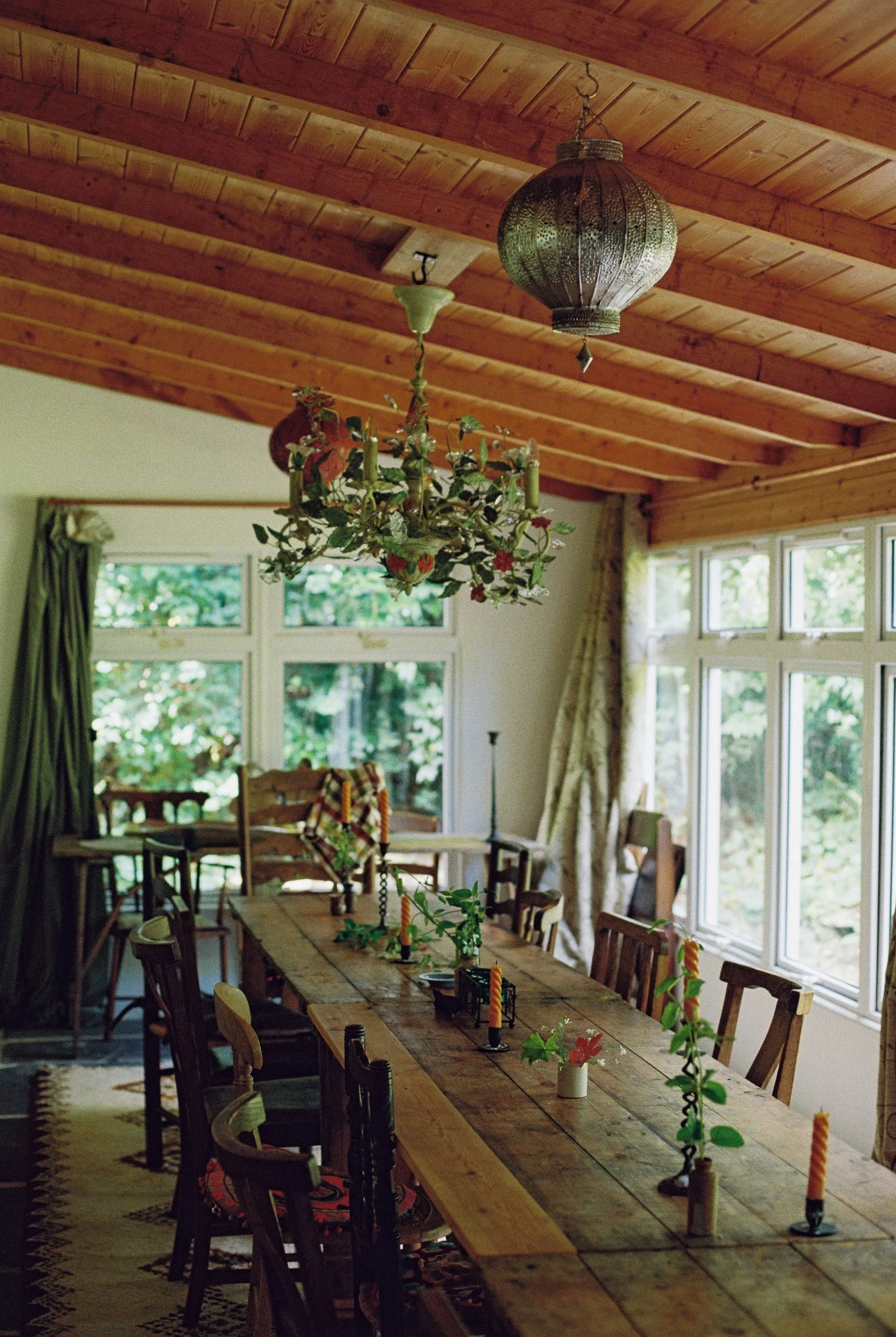 Light-filled garden room with long dining table and floral chandelier